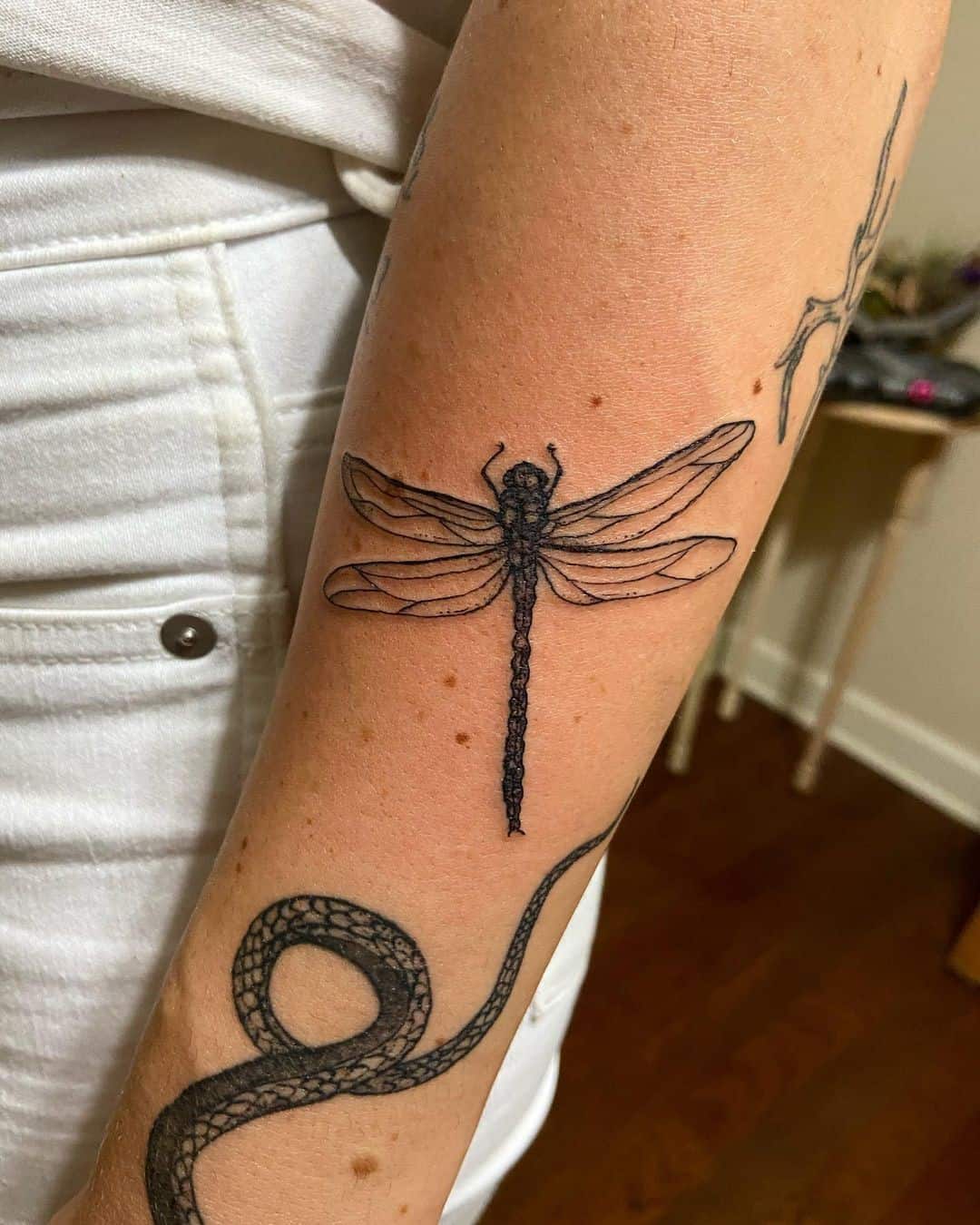 Tatuaje de libélula pequeña negra