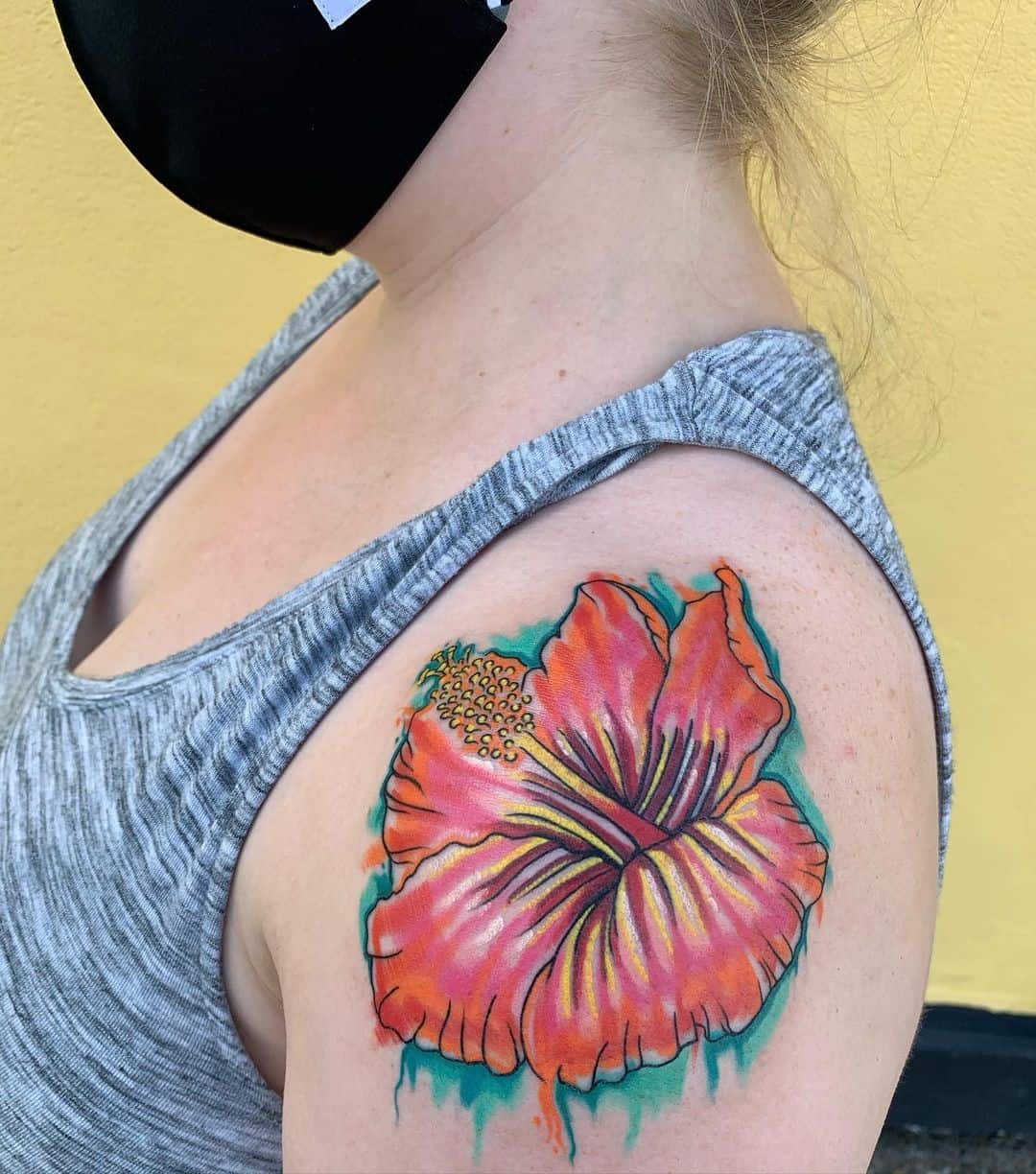 Tatuaje de flor de hibisco en el hombro para mujer.