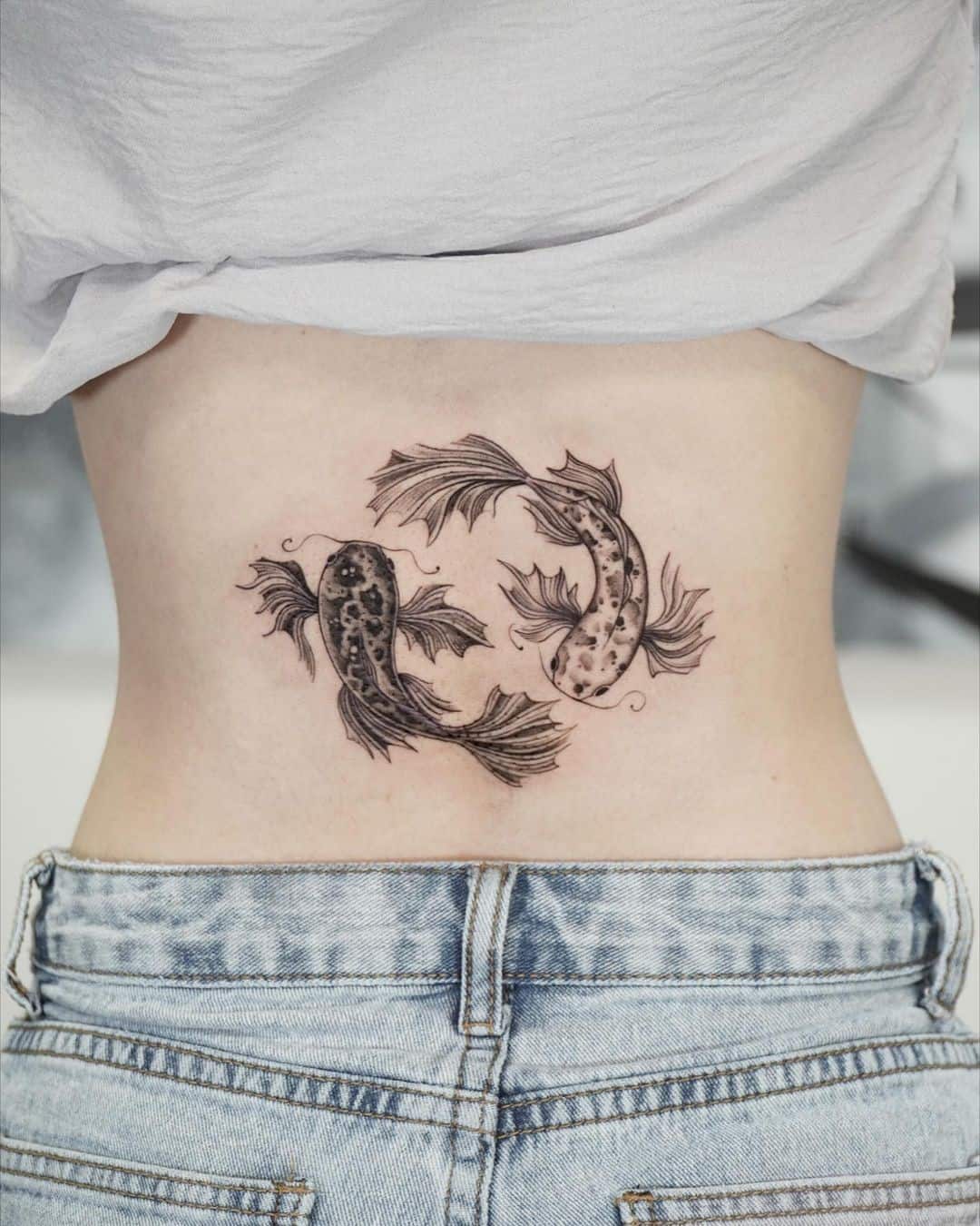 Tatuaje de pez koi yin yang en la espalda 
