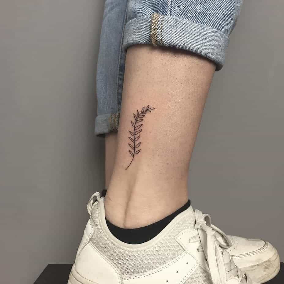 Tatuaje minimalista de helecho en la pierna 