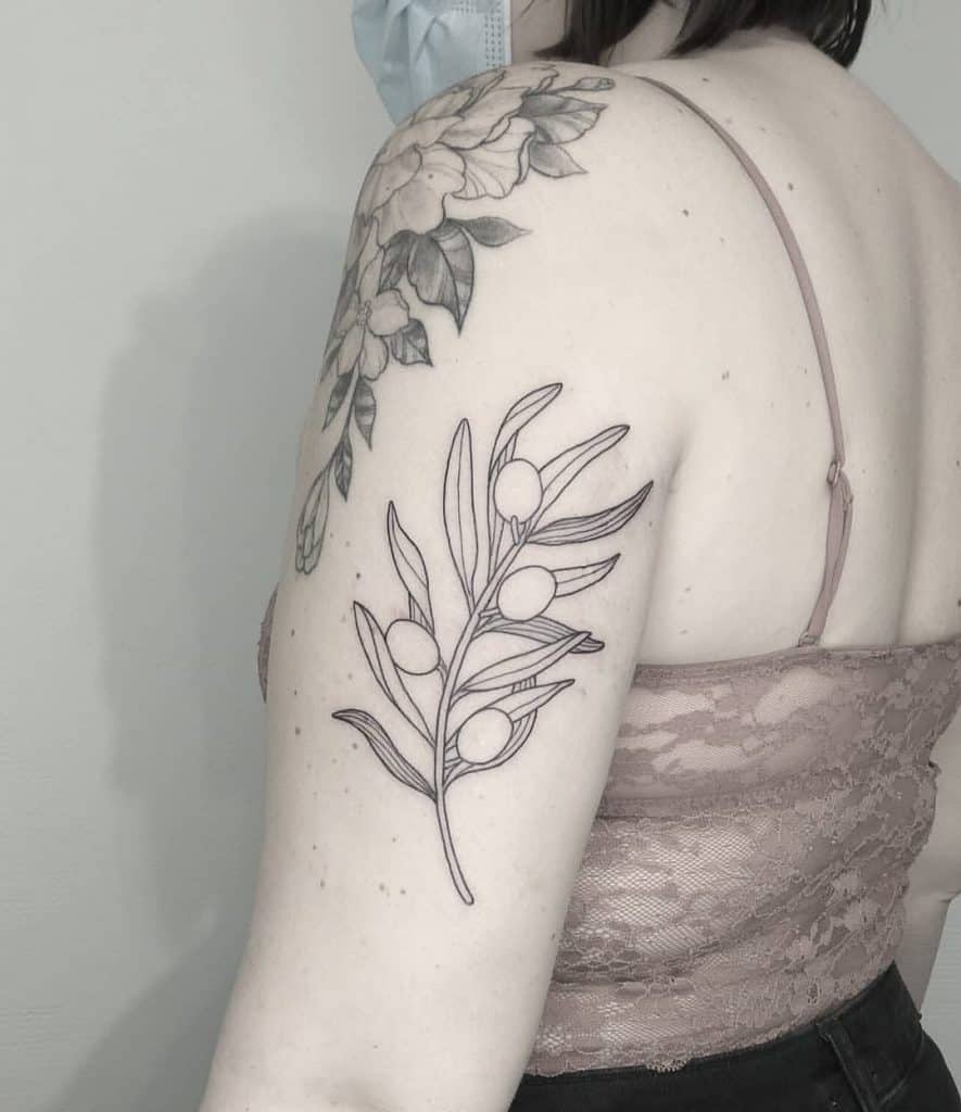 El tatuaje de la rama de olivo en el brazo.
