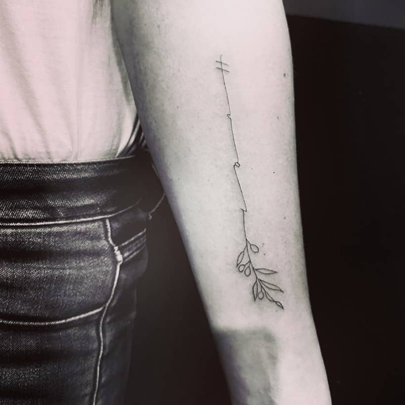 El tatuaje minimalista de la rama de olivo en el interior del brazo.