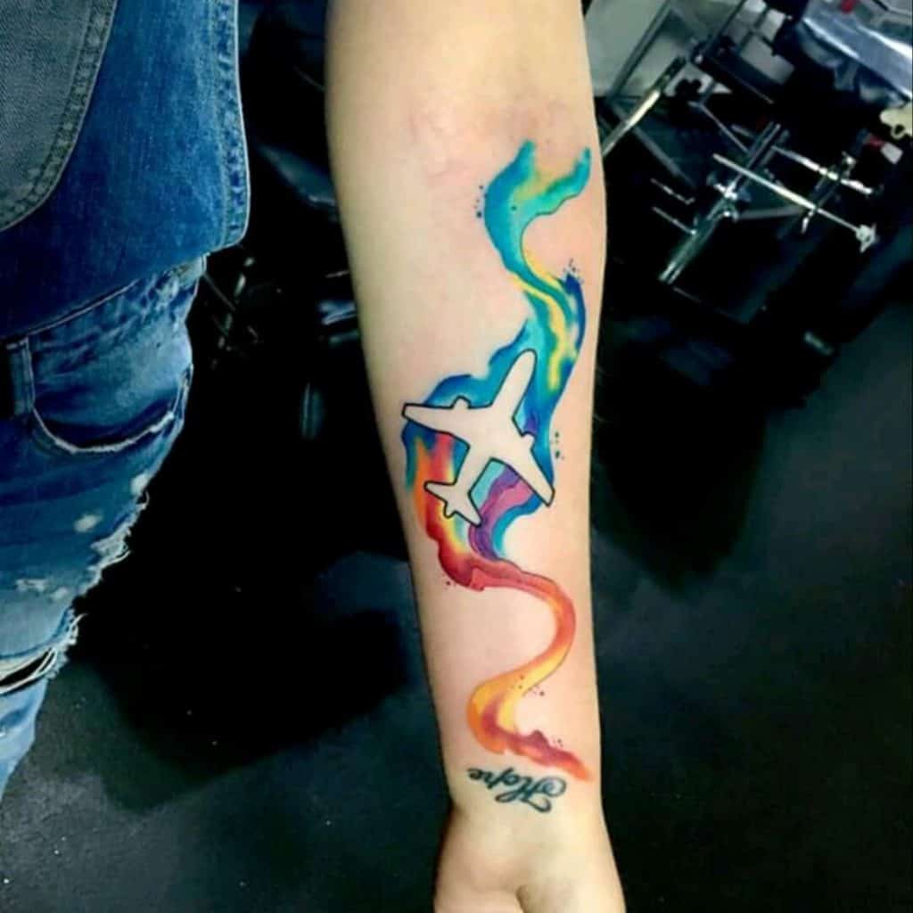 Tatuaje en el brazo, avión colorido y artístico