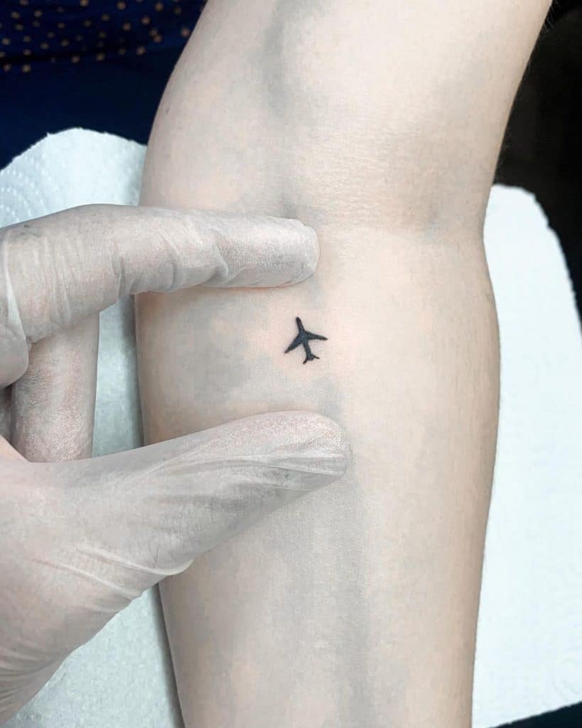 Pequeño y delicado tatuaje de avión