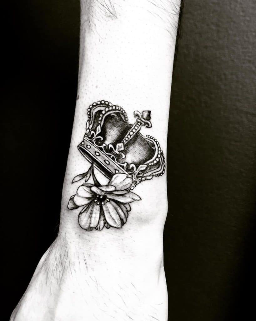 Tatuaje de corona negra y flores.