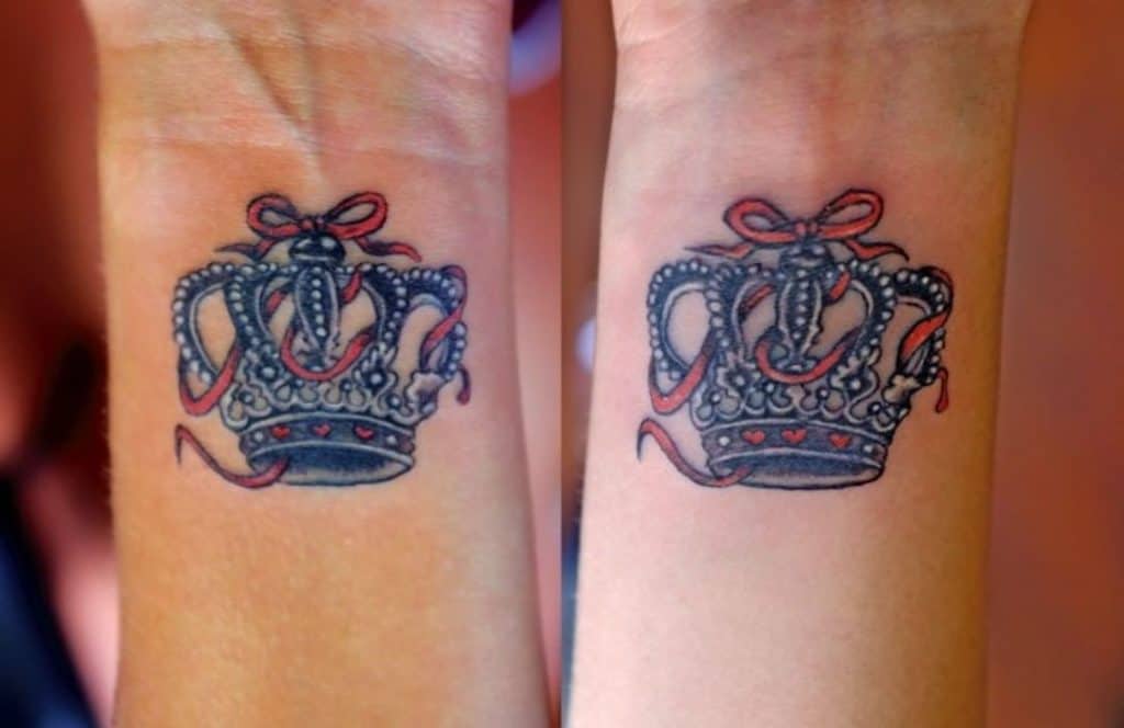 Tatuaje de corona roja en el brazo.