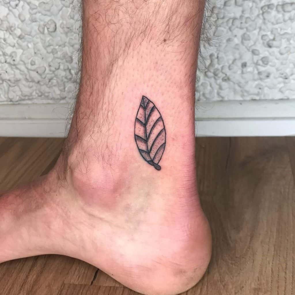 Tatuaje de una hoja en la pierna