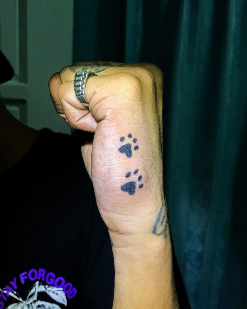 Tatuaje en la mano, dos patas de perro