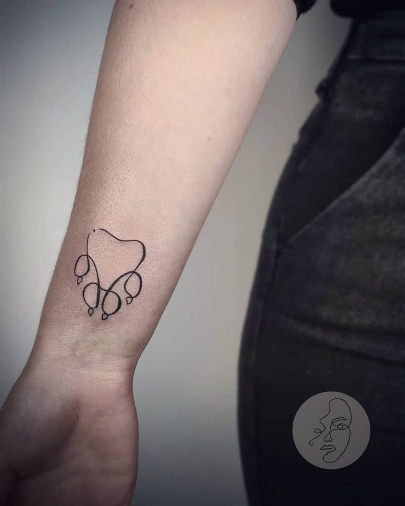 Tatuaje de pata de perro minimalista en el brazo