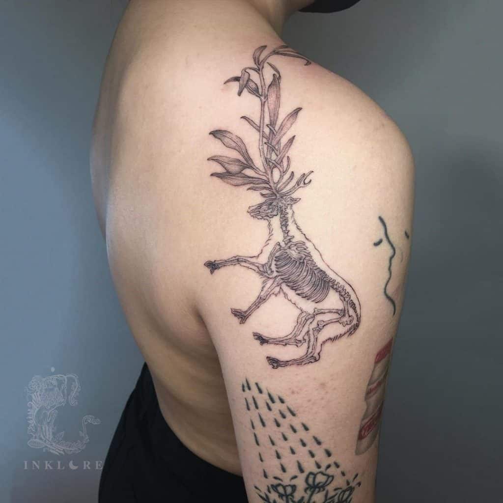 Tatuaje de ciervo en la parte superior de la espalda. 