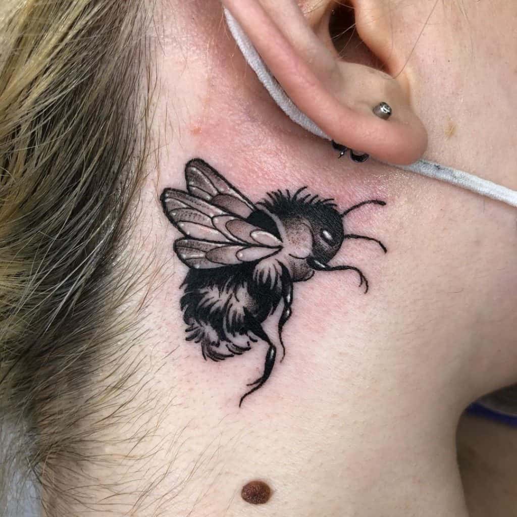 Tatuaje en la oreja, abeja, tinta negra 